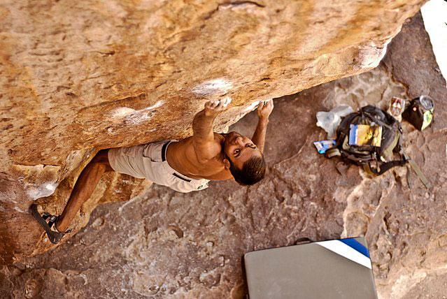 man bouldering in Hueco Tanks, Texas where the Hueco grading system was invented