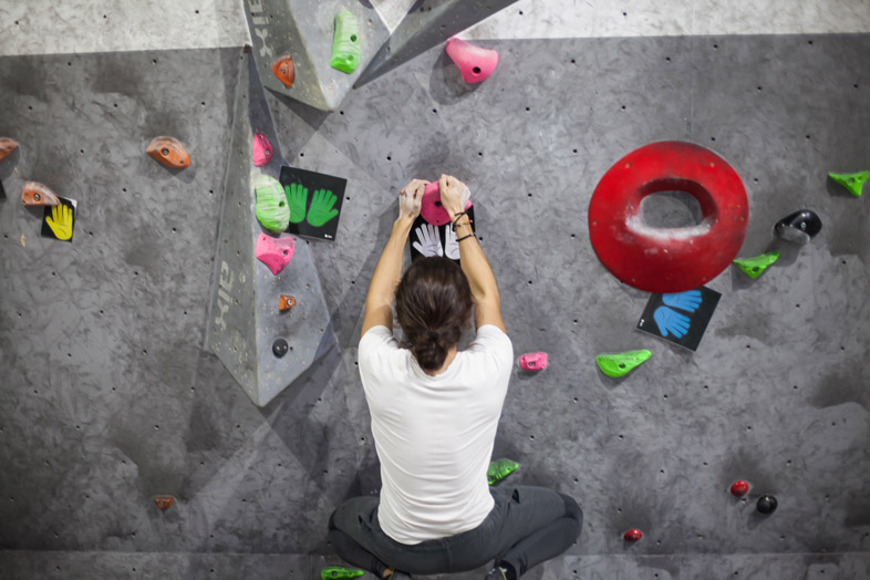 a climber in the start position of a boulder problem