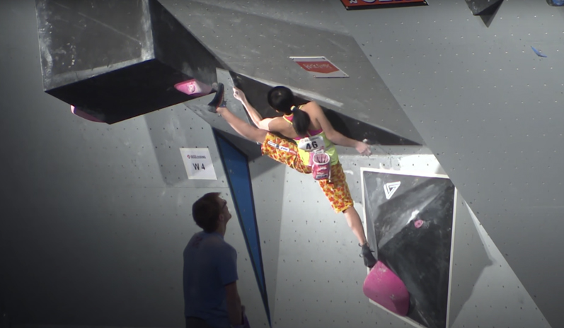 Ashima Shiraishi performing a split during a climbing competition. Flexibility is important in rock climbing and can be trained by doing yoga daily